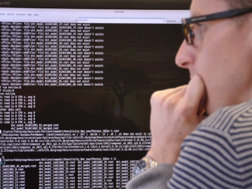 A male student looking at a screen with data